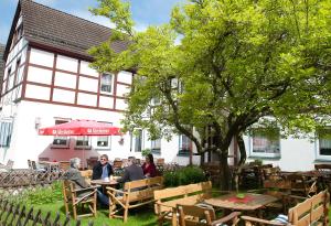 a group of people sitting at tables in front of a building at Hotel & Restaurant - Gasthaus Brandner in Trendelburg
