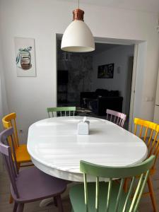 a dining room with a white table and chairs at Casa Good Vibes in Târgu-Mureş