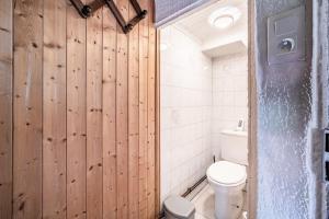 a bathroom with a toilet and a wooden wall at Maison De La Coutettaz in Morzine +13 photos