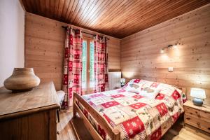 a bedroom with a bed and a wooden wall at Le petit Chalet in Morzine