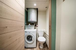 a small bathroom with a toilet and a washing machine at Chalet authentique en vallée verte in Bogève +33 photos