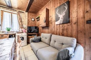 a living room with a couch and a deer on the wall at Maison De La Coutettaz in Morzine