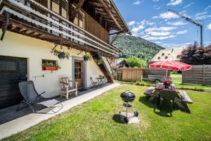 a patio with a table and an umbrella at Maison De La Coutettaz in Morzine