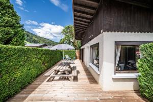 a patio with benches and an umbrella on a building at Le petit Chalet in Morzine