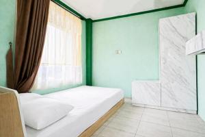 a small bedroom with a bed and a window at Cozzy Malakai Guesthouse in Palayangan