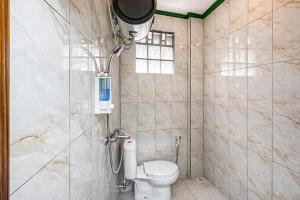 a bathroom with a shower with a toilet in it at Cozzy Malakai Guesthouse in Palayangan