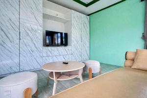 a living room with a table and a couch at Cozzy Malakai Guesthouse in Palayangan
