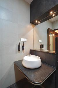 a bathroom with a white sink and a mirror at Singaras Coffee Country in Masinagudi +84 photos