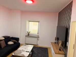 a living room with a couch and a tv at Casa del Mondo 4 in Sankt Aldegund