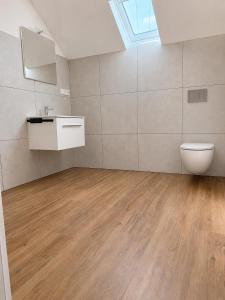 a bathroom with a toilet and a sink in a room at Casa del Mondo 4 in Sankt Aldegund +5 photos