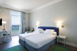 sypialnia z dużym białym łóżkiem i balkonem w obiekcie Hotel Niza w mieście San Sebastián +35 zdjęć