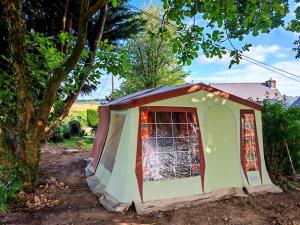 a green tent with a window in a tree at une nuit insolite en 1980 in Crédin +12 photos