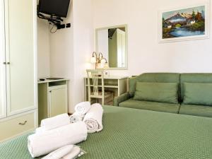 a living room with a couch and a bed with towels at Le Camere DI Lucia Affittacamere in Colà di Lazise