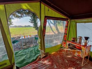 a green tent with a view of a field at une nuit insolite en 1980 in Crédin