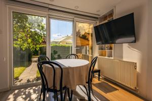 a dining room with a table and chairs and a large window at G's Place in Prishtinë