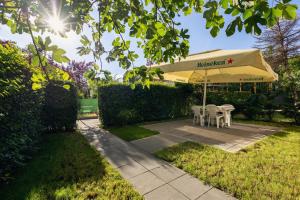 a table and chairs under an umbrella in a yard at G's Place in Prishtinë