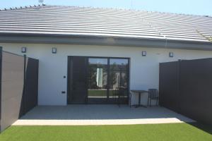 a house with a patio with a table and a fence at Apartmány Nitrianska osada in Bánov +6 photos