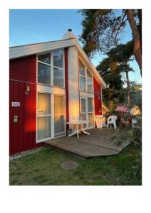 a red and white house with a table on a deck at Ferienhaus Baabe in Baabe