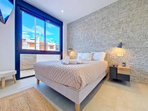 a bedroom with a large bed and a brick wall at La Llana Beach MDC - 8010 in Mar de Cristal +37 photos