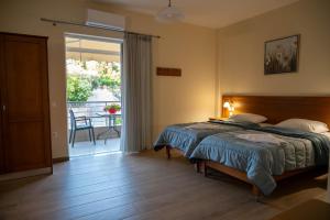 a bedroom with a bed and a door to a balcony at TRIANTAFYLLOY ROOMS in Loutra Edipsou