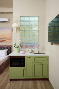 a green cabinet with a sink in a room at LangX Chapter Hotel & Apartment in Danang