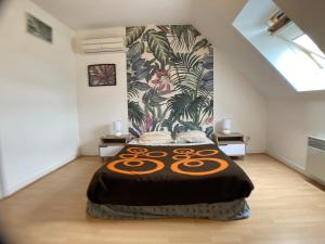 a bedroom with a large bed with a tropical wallpaper at Une jolie maison climatisée pour vous reposer in Blois