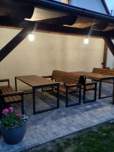 three wooden benches and a table and a potted plant at Agroturystyka u Pawła i Asi in Kobyla Góra
