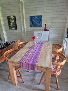 a wooden table with chairs and a vase of flowers on it at Ferienwohnung mit Pfiff in Siegsdorf +11 photos