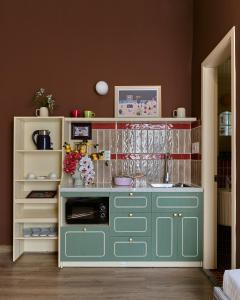 a kitchen with a green cabinet with a sink at LangX Chapter Hotel & Apartment in Danang