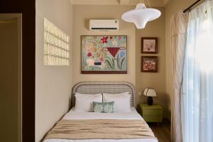 a bedroom with a bed and a painting on the wall at LangX Chapter Hotel & Apartment in Danang