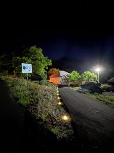 a street at night with lights on the side of the road at LOPATE mountain stone house in Lopate