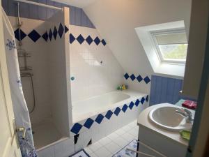 a bathroom with a white tub and a sink at Une jolie maison climatisée pour vous reposer in Blois +8 photos