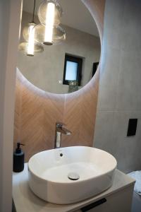 a white sink in a bathroom with a mirror at Craftowe domki in Rusinowo +29 photos