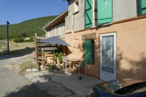 a table with an umbrella next to a building at Les bois rouges in La Rochegiron