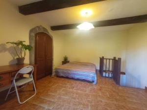 a bedroom with a bed and a desk and a chair at Mas de la Petite Occitane - Cévennes sud in Saint-André-de-Majencoules