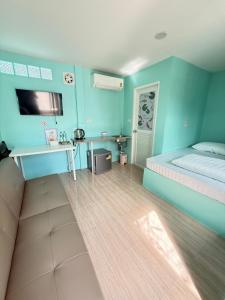 a blue room with a bed and a desk at BAN SUAN KRATOM CAFE AND RESORT in Nakhon Pathom