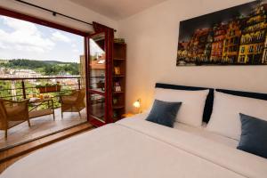 a bedroom with a white bed and a balcony at Apartmány Sonáta Luhačovice in Luhačovice