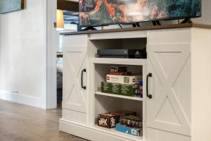 a white entertainment cabinet with a tv on top at Fall Line 107 in Telluride +26 photos