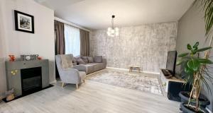 a living room with a couch and a tv at Elegant Garden Villa American Village Pipera in Voluntari