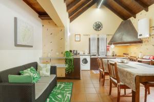 a kitchen and living room with a couch and a table at Sunset Village in São Jorge