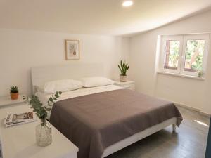 a white bedroom with a bed and two windows at Fiorucci Apartments - Marco's House in Focene