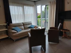 a living room with a couch and a table at Duplex met zwembad Neoportus in Nieuwpoort