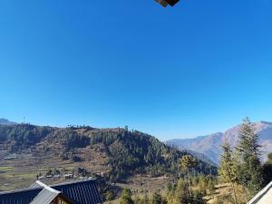 a view of a mountain from a house at Peak Paradise homestay in Sainj +3 photos
