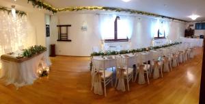 a row of tables with white chairs in a room at Relax Penzion U Adama in Dolná Tižina