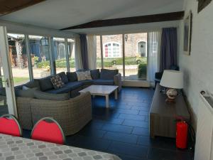 a living room with a couch and a table at Stegelshof 1 in Eygelshoven +5 photos