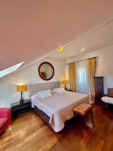 a bedroom with a large bed and a red couch at Ático en Plaza de la Constitución 3 bedrooms in Málaga