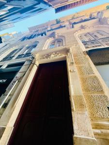 a building with a wooden door in front of it at Ático en Plaza de la Constitución 3 bedrooms in Málaga