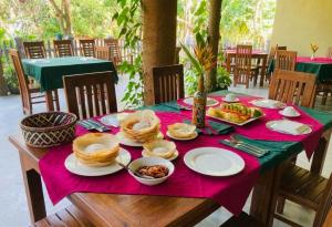 a table with plates of food on top at Sunshine Resort Sigiriya in Sigiriya