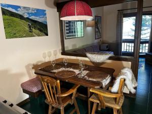 ein Esstisch mit Stühlen und einem Spiegel in der Unterkunft Sestriere-Sises Lodges, Appartamenti Moderni, vicino alle piste in Sestriere + 95 Fotos