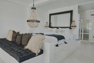 a white bedroom with a bed and a couch at White Palm Uluwatu - Wellness & Recovery Retreat - 2 Min Walk to Balangan Beach in Jimbaran